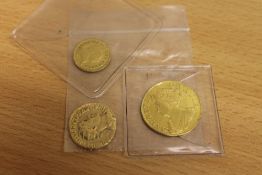 A Queen Anne Guinea 1713, together with 1/3 Guinea 1804 and one other gold coin.