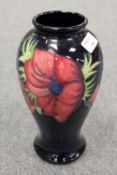 A Moorcroft tall vase decorated with amaryllis design, height 26 cm. CONDITION REPORT: Good