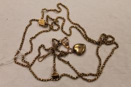 A 9ct gold guard chain upon which hangs a bow brooch, heart locket and citrine fob. CONDITION