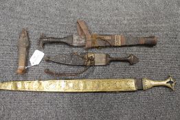 Two nineteenth century eastern daggers, with tooled leather scabbards, together with another
