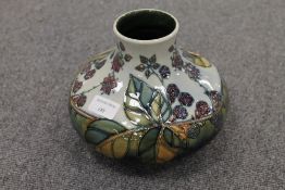 A Moorcroft pottery squat vase decorated with leaf and berries, height 16.5 cm. CONDITION REPORT: