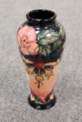A Moorcroft pottery vase decorated with tubelined flowers on peach ground, height 21 cm. CONDITION