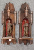 A pair of early twentieth century carved oak castelated wall brackets, each with standing spelter