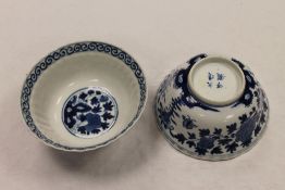 A pair of Chinese blue and white bowls, with floral decoration, four character marks to base,