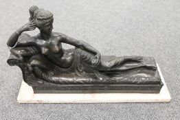 A French bronze figure depicting a lady reclining upon a couch, on marble plinth, width 46 cm.