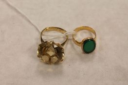 A 9ct gold citrine ring, together  with a yellow metal ring mounted with a green stone. (2)