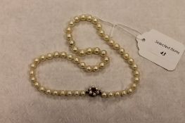 A pearl necklace with 9ct gold and amethyst clasp, length 46 cm. CONDITION REPORT: Good condition,