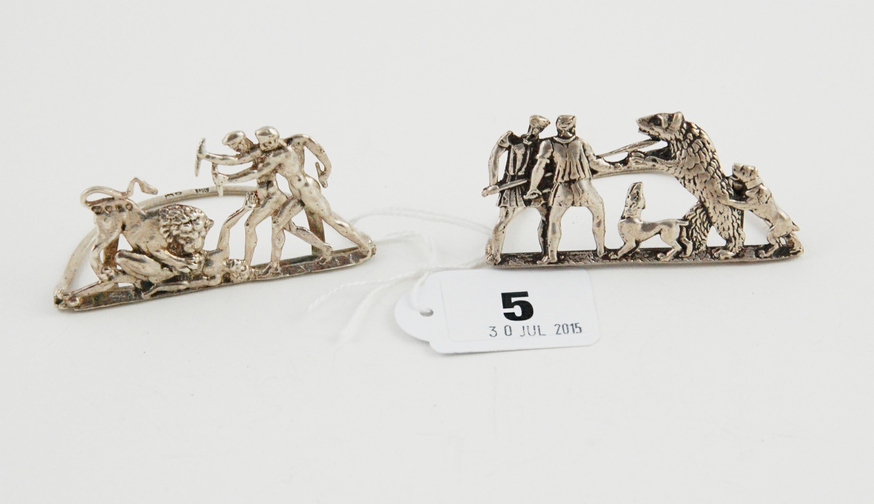 Pair of silver collapsible menu holders, one with pierced scenes of figures & a bear,