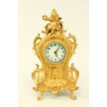 Gilt Metal New Haven Mantle Clock With cherub on top. Approx. 11" high.