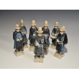 "20th century AD. A mixed group of glazed ceramic figurines, each in a blue robe and orange