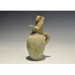 "20th century AD. A pale blue glazed composition jar with loop handle to the rear, figure to the