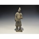 "20th century AD. A greyware ceramic figurine of a warrior in studded coat of plates with baggy