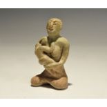 "14th-16th century AD. A green-glazed ceramic figurine of a nude seated female suckling a baby;