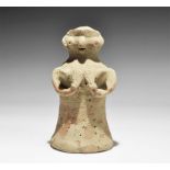 "3300-1700 BC. A bell-shaped ceramic figurine with globular head; applied arms supporting the