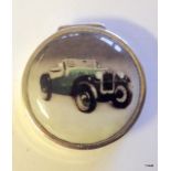 A silver and enamel pill box depicting a classic car