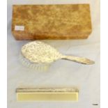 A silver musical hairbrush and comb set