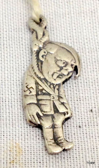 An extremely rare silver charm depicticting Adolf Hitler hanging from a noose