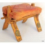 A folding wooden camel seat with decorated leather cushion 33h x 44w x 31d