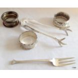 Silver napkin rings, sugar tongs and a fork 120gms
