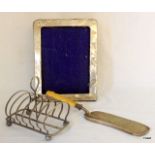 A silver picture frame, Victorian silver plated toast rack and a crumb tray with bone handle
