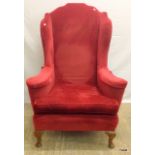 A red upholstered wing back chair