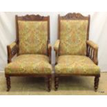 A pair of Edwardian oak framed embroidered fireside chairs