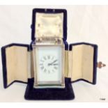 A silver case carriage clock with enamel face and original velvet case