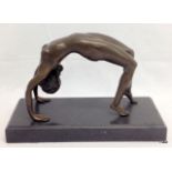 A bronze figure of a lady in a yoga position