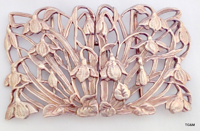 A silver belt buckle in the Art Nouveau style