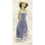 A Lladro figure of a girl with hands behind her back 21cm high