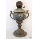 A Victorian cast metal oil lamp with cherub handles