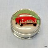 A silver pill box with enamel picture of a classic car