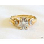 A gold ring set a large oval Moissanite (tests as a diamond) with diamond shoulders