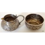 A white metal cream jug and sugar bowl with repouse pattern depicting safari animals