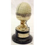 A Silver Dunlop  'Hole In One' golf ball souvenir on stand