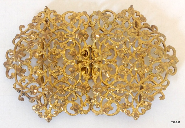 A gilt belt buckle with highly decorative garland pierced design