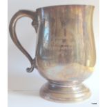 A silver drinking tankard with some engraving