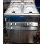 A stainless steel double deep fat fryer and warming oven