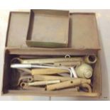 A metal tool box with tools including hammers and chisels