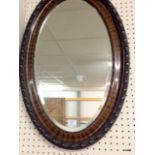 A  Victorian Oval Ebonised Bevelled Wall Mirror. 82 x 50