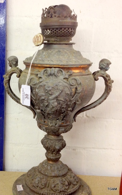 An ornate cast iron oil lamp