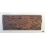 A Boer War wood cribbage board with TW HUW LADYSMITH SA 30 FEB 1900 carved into it 28 x 11 cms