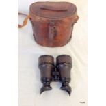 A pair of binoculars in a military leather case