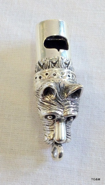 A silver whistle in the form of a dog