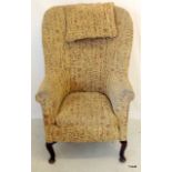 An upholstered wing back tub chair on cabriole legs 108 x 69 x 46cm