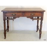 A late Victorian oak writing desk standing on turned supports and brass castors