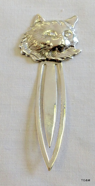 A large silver bookmark in the form of a cat