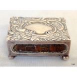 A silver hallmarked matchbox cover ornately decorated with repousse floral, scroll and beadwork
