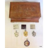 A wooden box with various sports medals some silver