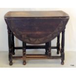 An oak carved oval drop leaf table